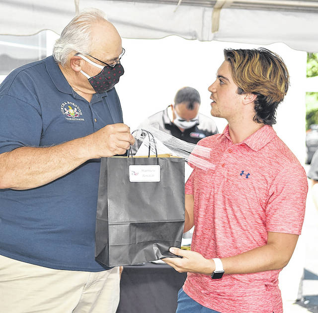 <p>Duryea Mayor Keith Moss hands a giftbag to Matthew Rinaldi, a Pittston Area 2020 graduate, also a Duryea Lion’s Club Scholarship recipient.</p>
<p>Tony Callaio | For Sunday Dispatch</p>