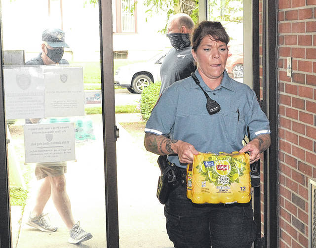 125351097_web1_Mason-s-Donation-1
West Pittston police officer Jessica Mancus-Barlotta carries in a half case of ice tea donated by West Pittston Masonic Lodge No. 499 on Thursday. Following behind are Masons Shaun Korus, left, and Pete Nemshick.