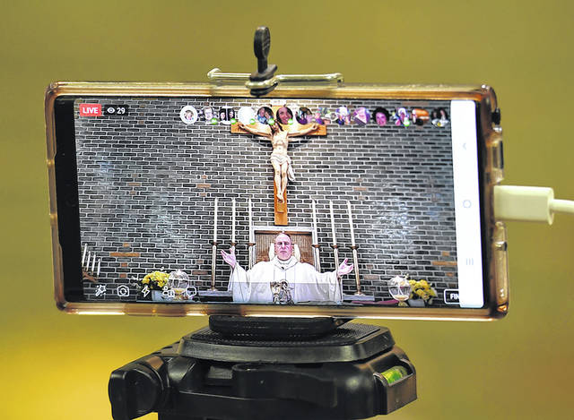 <p>Modern technoloy such as using a cellphone allows Father Paul McDonnell to broadcast Mass live via the internet around the world.</p>
<p>Tony Callaio | For Sunday Dispatch</p>