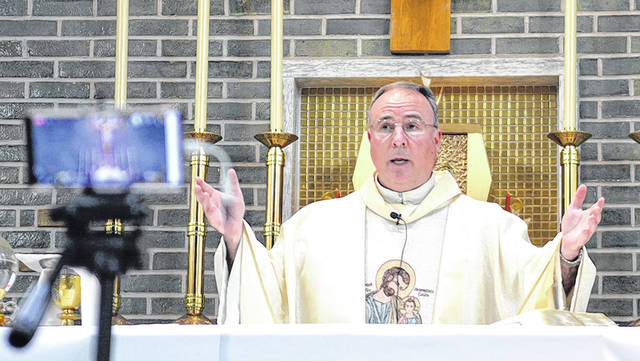 <p>Father Paul McDonnell celebrates Mass at the Oblates of St. Joseph, Laflin, with his personal cellphone doubling as the camera for a live shot.</p>
<p>Tony Callaio | For Sunday Dispatch</p>