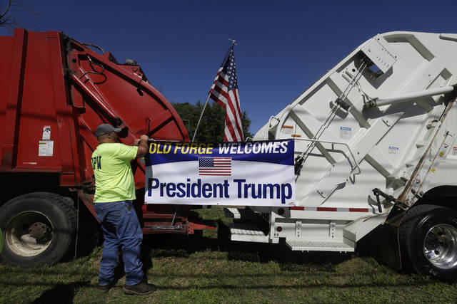 <p>A supporter of President Donald Trump hangs a banner on Department of Public Works vehicles before the arrival of President Donald Trump on Thursday in Old Forge.</p>
<p>Jacqueline Larma | AP photo</p>
