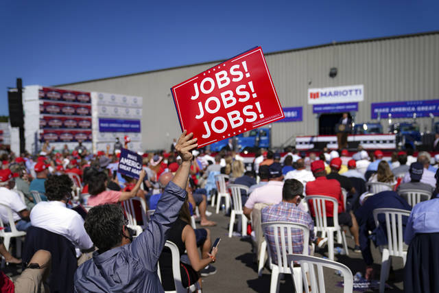 <p>A supporter holds up a sign while President Donald Trump speaks Thursday during a campaign rally at Mariotti Building Products in Old Forge.</p>
<p>John Minchillo | AP photo</p>