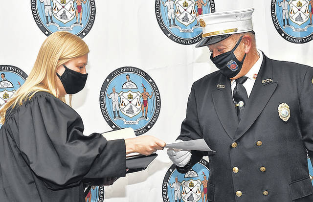 <p>District Magistrate Judge Alexandra Kokura hands newly sworn in Pittston Fire Chief Frank Roman his oath of office certificate.</p>
<p>Tony Callaio | For Times Leader</p>
