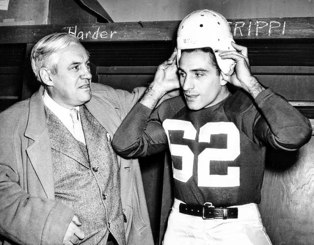 <p>Charley Trippi, right, 24-year-old All-America halfback tries on a Chicago Cardinal uniform at Comiskey Park in Chicago, Jan. 17, 1947. Trippi signed a four-season $100,000 contract with the NFL. Cardinal coach Jimmy Conzelman looks on.</p>
<p>AP file photo</p>