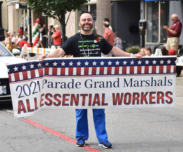 <p>Nurse Tommy Hennigan, representing essential workers, carries a banner down Main Street, Pittston, for the annual Pittston Tomato Festival parade. </p>
<p>Tony Callaio | For Sunday Dispatch</p>