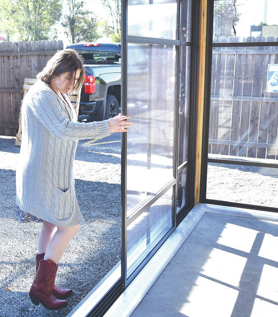 <p>Trista Cruz, partner of American Grill, demonstrates how the newly installed sliding doors could be closed, opened or removed to their 40’ x 40’ pavilion.</p>
<p>Tony Callaio | For Sunday Dispatch</p>