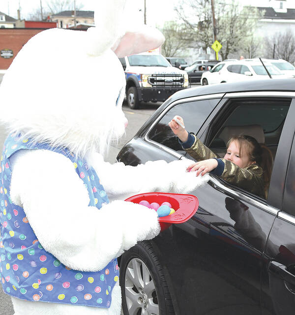 <p>Six-year-old Liliana Watkins reaches for an egg from the Easter Bunny during the drive through.</p>
<p>Tony Callaio | For Sunday Dispatch</p>