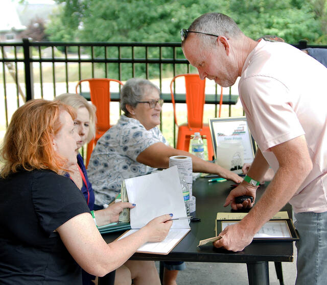 <p>Pat Tracy, right, checks in at the Greater Pittston Santa Squad Christmas in July event at the Susquehanna Brewing Co. on Sunday, July 17.</p>
<p>Tony Callaio | For Sunday Dispatch</p>