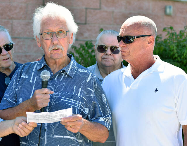 <p>An emotional Pat Clifford, while addressing the crowd gathered honoring his brother Michael Clifford, is embraced by Rick Romanko, whose brother Daniel was also being honored at a ceremony at Avoca Municipal Building.</p>