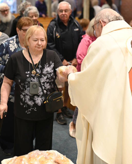 <p>Fr. Joseph Sibliano, O.S.J., right, offers bread to Marianne Cameli and the rest of the congregation at the Oblates of St. Joseph Seminary, Laflin, during the St. Joseph the Worker Mass on Labor Day.</p>
<p>Tony Callaio | For Sunday Dispatch</p>