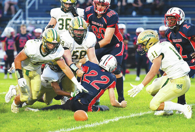 <p>Trojan running back Zack Fox (22) fumbled the ball and the Warriors Aaron Crossley (5), left, and James Hizynski (11) converge to recover the ball for a turnover.</p>
<p>Tony Callaio | For Sunday Dispatch</p>
