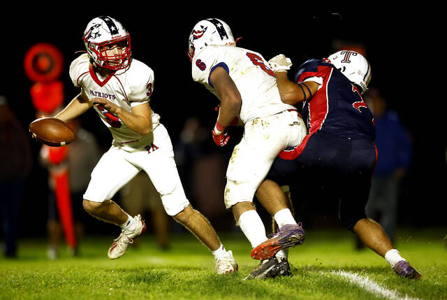 <p>Pittston Area quarterback Drew DeLucca, left, scrambles away from pressure on Friday night against Nanticoke Area.</p>
<p>Fred Adams | For Times Leader</p>