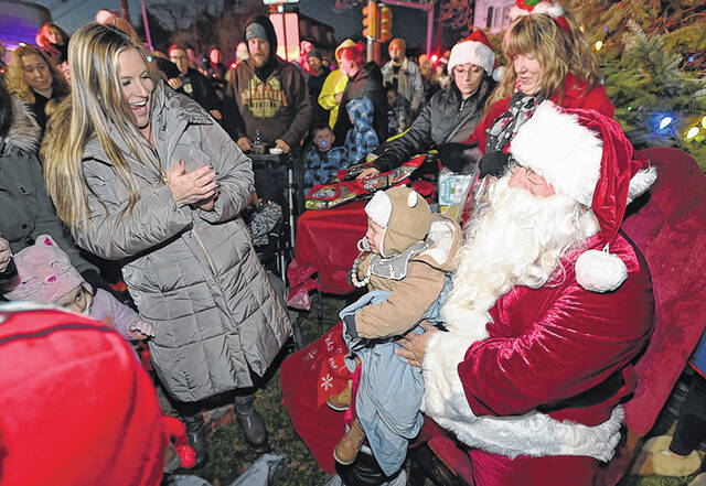 <p>Fifteen-month-old Noah Witek was not sure how to take sitting on Santa’s lap with monther, Michelle, looking on.</p>
<p>Tony Callaio | For Sunday Dispatch</p>