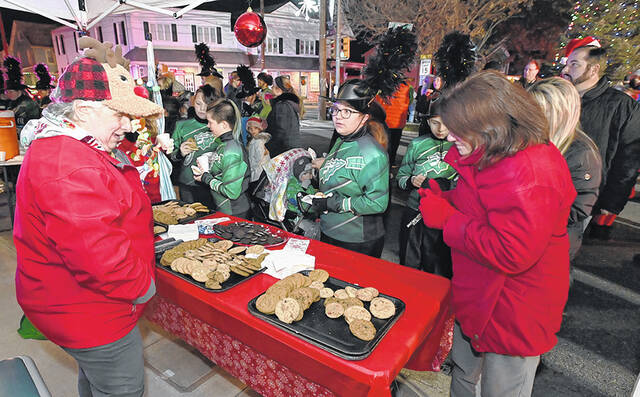 <p>West Pittston Santa parade volunteer Nancy Smith, left, gives a helping hand at the cookie stand next to the hot chocolate stand.</p>
<p>Tony Callaio | For Sunday Dispatch</p>