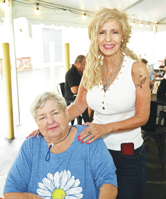 <p>Diane Luke stands behind Greater Pittston Santa Squad founder, Anthony Marranca’s mom, Mary Marranca.</p>
<p>Tony Callaio | For Sunday Dispatch</p>