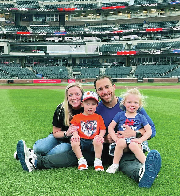 <p>Three and a half-year-old twins Logan, left, and Adelyn, right, sit with mom Angela, and dad Dustin at their father’s office, Citi Field, home of the New York Mets where he is the head strength and conditioning coach.</p>
<p>Submitted photo</p>