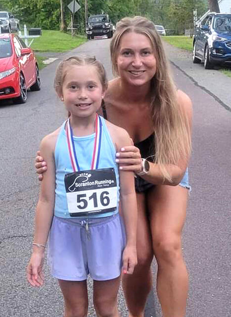 <p>Natalie Ruggles, 8, of West Pittston, stands with her mother, Rebecca, who is an accomplished runner herself, at the completion of the Jack Daniels Mile Run at Tunkhannock. Natalie smashed the course record in the 8-and-under division.</p>
<p>Submitted Photo</p>