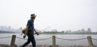 
			
				                                A man walks along the St. Lawrence River in front of the Old Port of Montreal on Friday. Smoke from the wildfires in the Canadian Prairies is causing poor air quality and reduced visibility in the Greater Montreal region.
                                 The Canadian Press via AP

			
		