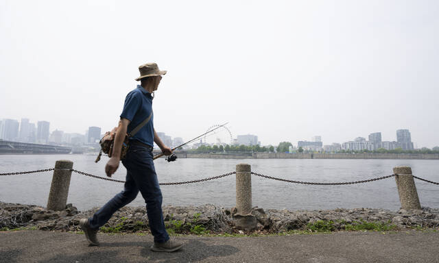 131569687_web1_131569687-23d2f928979442d4b8cacff1fb68f8ab
A man walks along the St. Lawrence River in front of the Old Port of Montreal on Friday. Smoke from the wildfires in the Canadian Prairies is causing poor air quality and reduced visibility in the Greater Montreal region.
The Canadian Press via AP