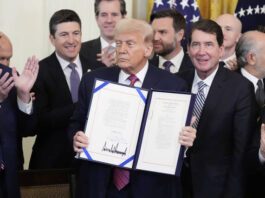 
			
				                                President Donald Trump holds up the GENIUS Act, a bill that regulates stablecoins, a type of cryptocurrency, after he signs the bill in the East Room of the White House on Friday in Washington.
                                 AP Photo

			
		