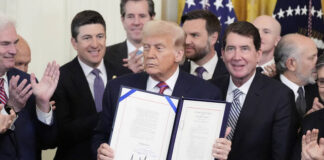 
			
				                                President Donald Trump holds up the GENIUS Act, a bill that regulates stablecoins, a type of cryptocurrency, after he signs the bill in the East Room of the White House on Friday in Washington.
                                 AP Photo

			
		