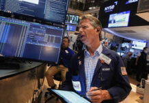 
			
				                                Trader Robert Charmak works on the floor of the New York Stock Exchange on Friday.
                                 AP Photo

			
		