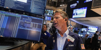
			
				                                Trader Robert Charmak works on the floor of the New York Stock Exchange on Friday.
                                 AP Photo

			
		