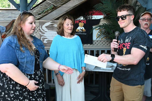 <p>Peter Sidari, brother of the late Dr. Jennifer Sidari, hands Shawna Williams, left, and Bette Saxton, center, of Dinner for Kids, a $10,000 check from the Dr. Jen’s Hope Foundation.</p>
<p>Tony Callaio | For Sunday Dispatch</p>