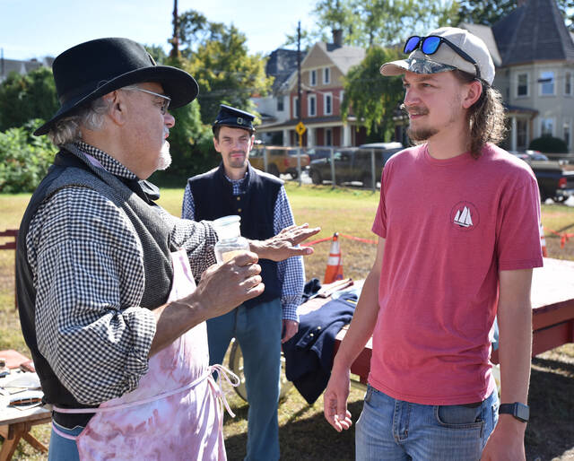 <p>Marc Kahn, left, and Daniel Shaw, center, talk to Hunter Lacomis, right, and Christine Lacomis (off camera) about life working at a Civil War Army Hospital.</p>
<p>Tony Callaio | For Sunday Dispatch</p>