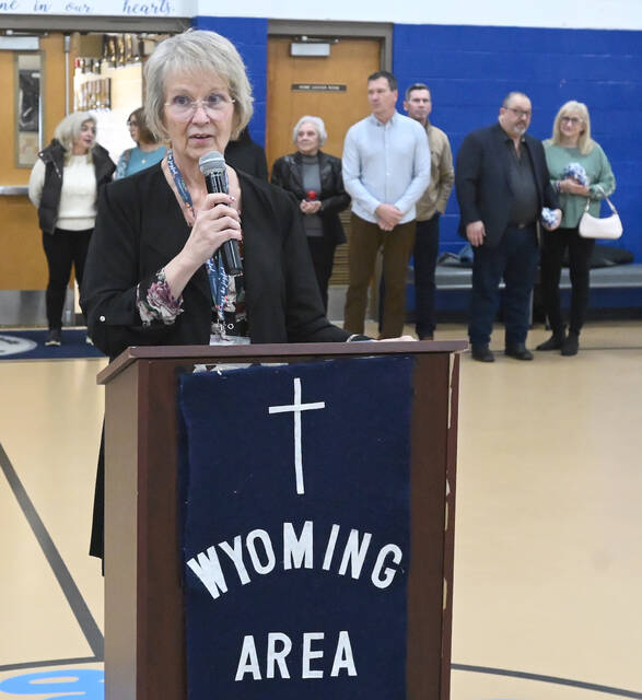 <p>Wyoming Area Catholic Principal Eileen Rishcoff stands at the podium to address the student body about the WAC Kindness Award, with members of the WAC Class of 1980, the award’s sponsors, in the background.</p>
<p>Tony Callaio | For Sunday Dispatch</p>