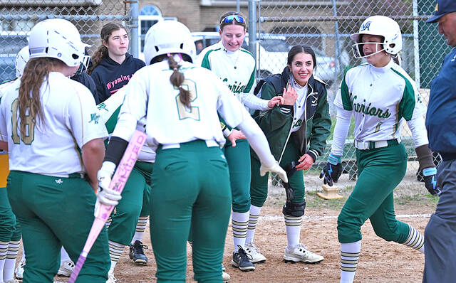 <p>Wyoming Area leadoff hitter Josie Kivak, right, is welcomed at home plate after hitting a solo home run against Holy Redeemer in the fourth inning.</p>
<p>Tony Callaio | For Times Leader</p>