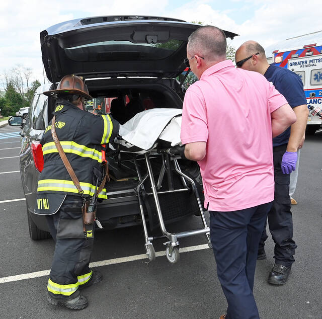 <p>Luzerne County Coroner Dion Fernandes, center, loads the mock car crash ‘deceased’ into the van.</p>
<p>Tony Callaio | For Sunday Dispatch</p>