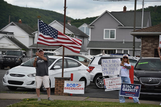 <p>Protesters hold signs and an American flag on the sidewalk across from The Avenue Restaurant and Catering in Wyoming, where Scranton Mayor Paige Cognetti and Gov. Josh Shapiro held a campaign event on Wednesday afternoon.</p>
<p>Liz Baumeister | Sunday Dispatch</p>