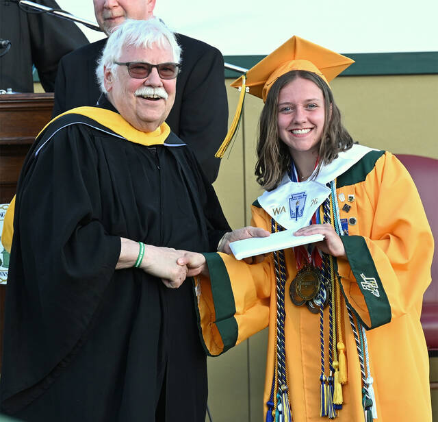 <p>Wyoming Area Class of 2026 secretary, Sofia Menta, is handed her diploma by Wyoming Area School Board member Joe Kopko. </p>
<p>Tony Callaio | For Times Leader</p>