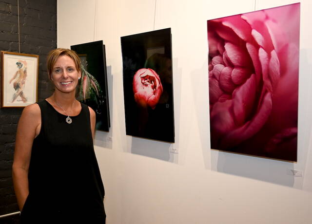 <p>Photographer Mary Kroptavich stands before three of her photos displayed on acrylic</p>
<p>Tony Callaio | For Sunday Dispatch</p>